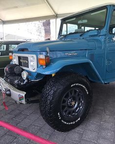 a blue truck is parked under a tent