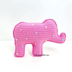 a pink crocheted elephant sitting on top of a white table