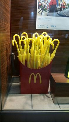 a bunch of yellow umbrellas in a red container