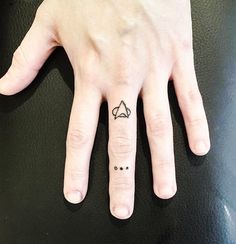 a person's hand with a small tattoo on it