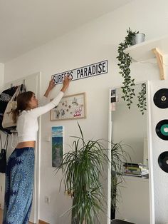 the woman is hanging up her clothes on the wall