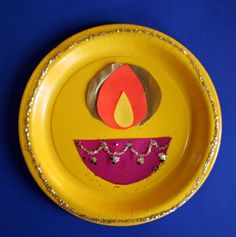 a yellow paper plate with a design on the bottom and a candle painted on it