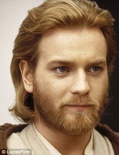 a man with long hair and beard wearing a brown sweater is looking at the camera