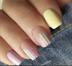 a woman's hand with pink and yellow nail polishes on her nails,