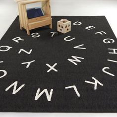 a black rug with white letters on it and a wooden chair next to it in front of a television