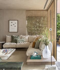 a living room filled with lots of furniture next to a wall covered in bamboo blinds