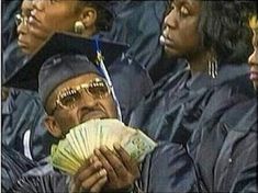 a group of people in graduation caps and gowns are holding up cash bills while looking at the camera