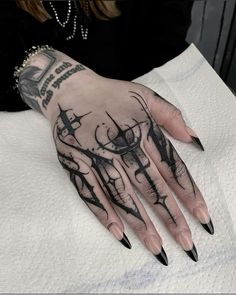 a woman's hand with black and white tattoos on it