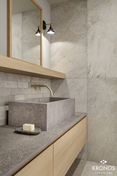 a bathroom with marble counter tops and wooden cabinets, along with a mirror above the sink