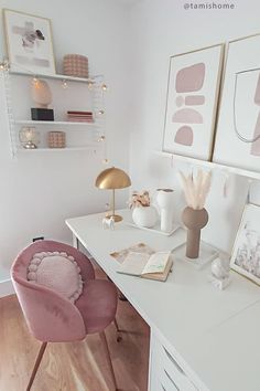 a white desk topped with a pink chair next to a wall mounted art work area