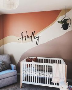 a baby's room with a crib, chair and wall mural that says handley