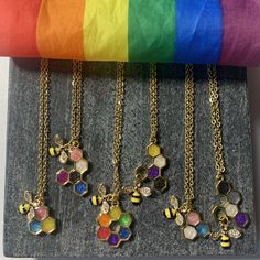 "Bee Proud of who you are and who you love! These chains are 14k gold plated stainless steel and are 18\" in length and paired with a gold alloy honey comb that has been hand dipped with the respective colors for the LGBTQIA+ community." Pride Jewelry, Pride Necklace, Trans Pride Flag, Pride Jewellery, Rainbow Flag Pride, Bee Sticker, Bee Necklace, Gold Alloys, Rainbow Pride