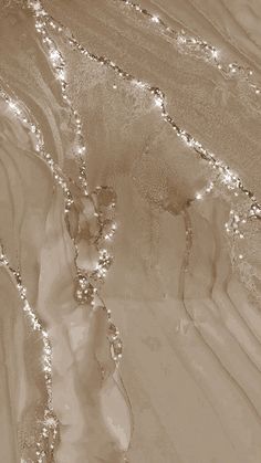 an aerial view of water and sand with lights on the beach in sepia tone