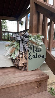 a sign that says miss eaton on the side of a wooden stair case with an animal print bow and tassel