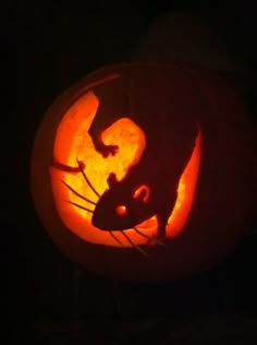 a rat carved into a pumpkin in the dark