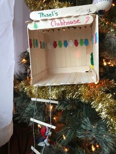 a christmas tree with a wooden toy house on it