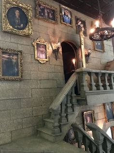 an old building with pictures on the wall and stairs leading up to the second floor