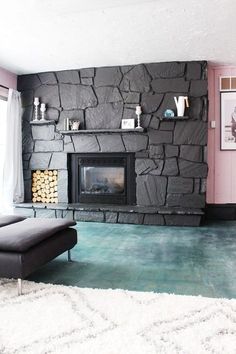 a living room with a stone fireplace and white rugs on the floor in front of it