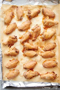 chicken wings are on top of tin foil and ready to be baked in the oven