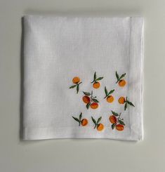 an embroidered napkin with oranges on it