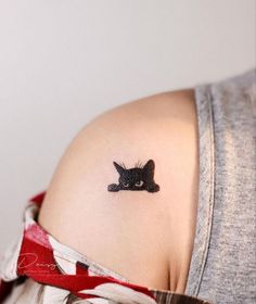 a woman with a cat tattoo on her shoulder