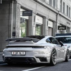 two white cars parked next to each other on the street