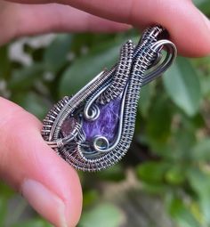 "Stunning sugilite cabochon, wrapped in yards of antiqued sterling silver. Placed with a small, rough, pink tourmaline.  Polished to add a unique finish. One of a kind. Comes with 18\"-20\" (adjustable) stainless steel chain.  Each piece is made with love & care in hopes they will last you a lifetime." Artisan Jewelry With Purple Natural Stones, Artisan Purple Jewelry With Natural Stones, Artisan Purple Gemstone Jewelry, Artisan Purple Wire Wrapped Necklace, Artisan Purple Amethyst Jewelry, Unique Purple Jewelry With Natural Stones, Artisan Oval Hand-wrapped Jewelry, Artisan Hand Wrapped Oval Jewelry, Wire Wrapped Amethyst Pendant Jewelry