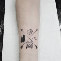 a small tattoo on the arm of a person with an arrow and camper van