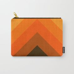 an orange and brown geometrical pattern carry - all pouch with gold zipper closures