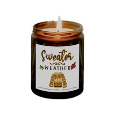 a candle that is sitting in front of a white background with the words sweater weather on it