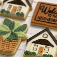 some decorated cookies are sitting on a table with the words welcome to the neighborhood painted on them