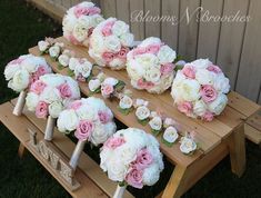 wedding bouquets are laid out on a wooden bench