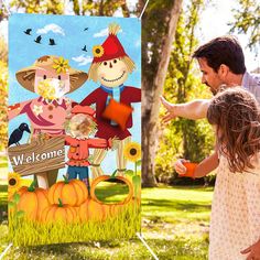 a father and daughter pointing at a welcome sign in the grass with scarecrows on it