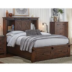 a bed sitting in a bedroom next to a night stand and dresser with two drawers