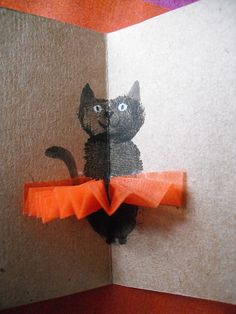 an origami cat is sitting on top of a piece of paper