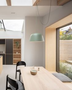 an open kitchen and dining room area with skylights above the countertop, along with black chairs