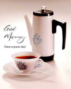 a tea cup and saucer sitting next to a coffee pot on a white table