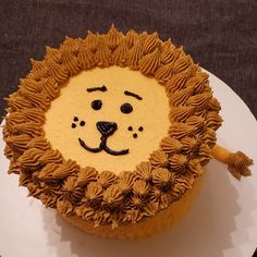 a lion cake with icing on a white plate