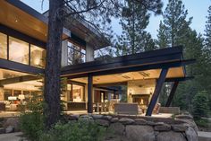 a modern house with large windows in the woods