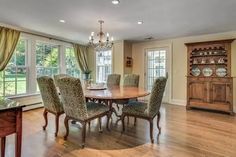 a dinning room table and chairs in front of a large window