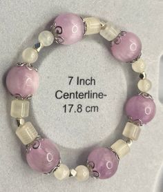 Enjoy the gentle and peaceful qualities of lavendar Kunzite with layers of tranquil Green Calcite in this calming, yet rejuvenating, stretch bracelet. Kunzite is a crystal displaying striations on the surface of semi-rare lavender to lilac pink, transparent crystals. It is of a variety of spodumene, with the color coming from trace amounts of manganese. Green Calcite is a UV-reactive, translucent crystal made up of fine-grained banded deposit of calcite. Calcite is derived from the German "Calcit", a term from the 19th century that came from the Latin word for lime, "calx" with the suffix "-ite" used to name minerals. Green Calcite, Latin Word, Lilac Pink, Latin Words, Uv Reactive, Stretch Bracelet, Stretch Bracelets, 19th Century, Lilac