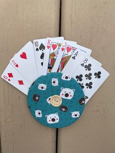 playing cards are sitting on top of each other in front of a wooden door with an animal theme