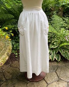 "No more frills or flounces of the Victorian period, just clean lines, definitive style, and the freedom to move!  This twill skirt was probably made around 1918 in our estimation.  There are 2 pockets, each sporting a button, there is a pleat in the back that opens up into a 9\" open kickpleat,, and the unusual double waistband (it grabs you firmly with the inner layer, but looks less strict from the outside) closes up with snaps and hooks.  There is a 3\" hem. Waist 26\" Hips 56\" Length 37\"" Cotton Skirt With Pockets For Daywear, Vintage Gathered Skirt For Daywear, Vintage White Tiered Skirt, Vintage White Skirted Bottoms, Cotton Skirt For Daywear, Vintage Summer Skirt For Daywear, Vintage White Bottoms For Daywear, Classic Skirt With Pockets For Daytime, Classic Skirt With Pockets For Daywear