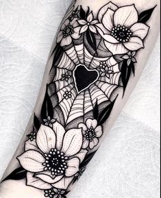 a black and white tattoo with flowers on the arm