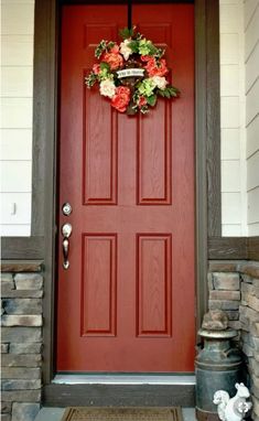 a red front door with a wreath on it