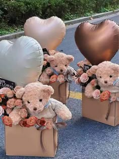 three teddy bears are sitting in boxes with balloons and flowers on the ground next to them