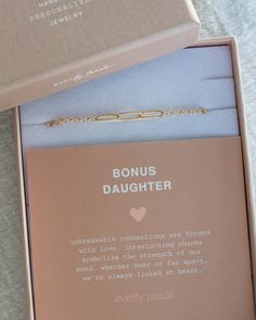 the box is open and has a chain on it that says,'bonus daughter '