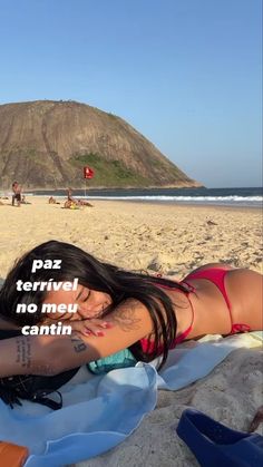 a woman laying on top of a beach next to a blue towel with the words papaz terrivel no meu cantin