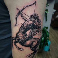 a man's arm with a black and white tattoo of a bow hunter on it