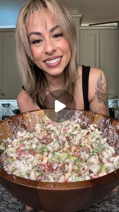 a woman holding a large bowl filled with food